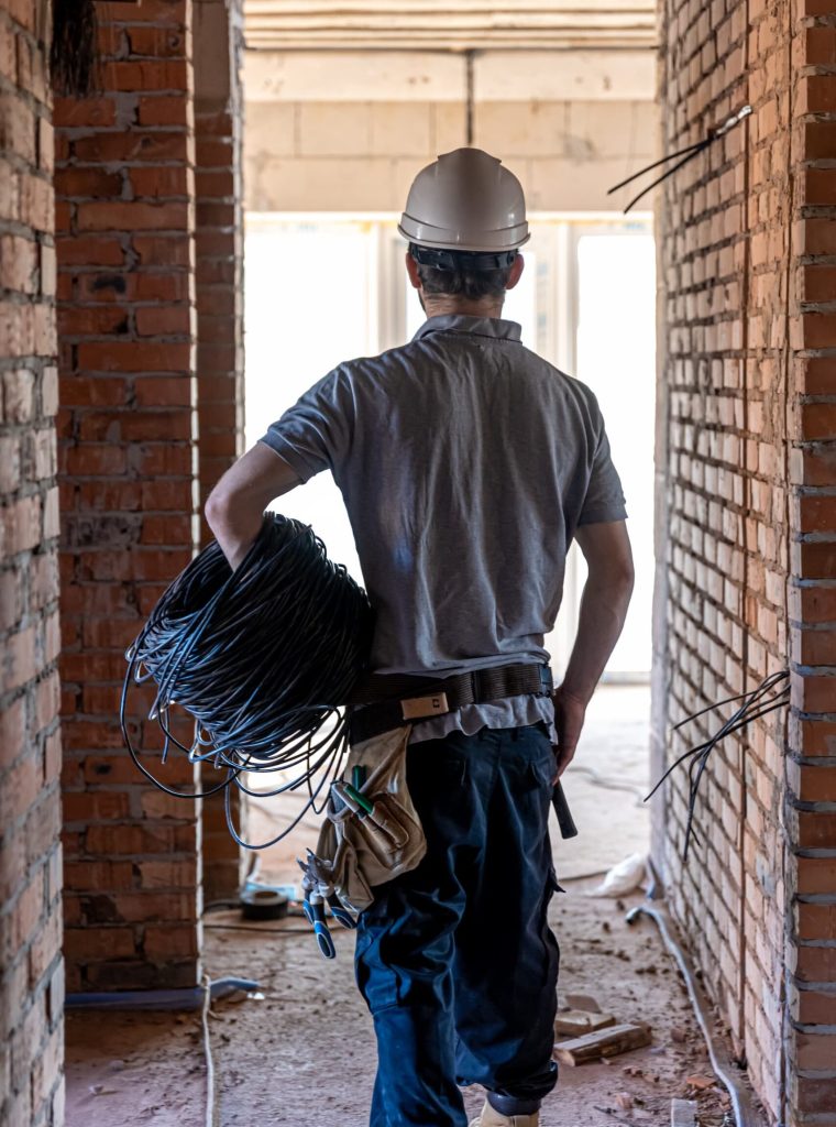 electrician-examines-construction-drawing-while-holding-electrical-cable-his-hand-work-site (1) electrician-examines-construction-drawing-while-holding-electrical-cable-his-hand-work-site (1)